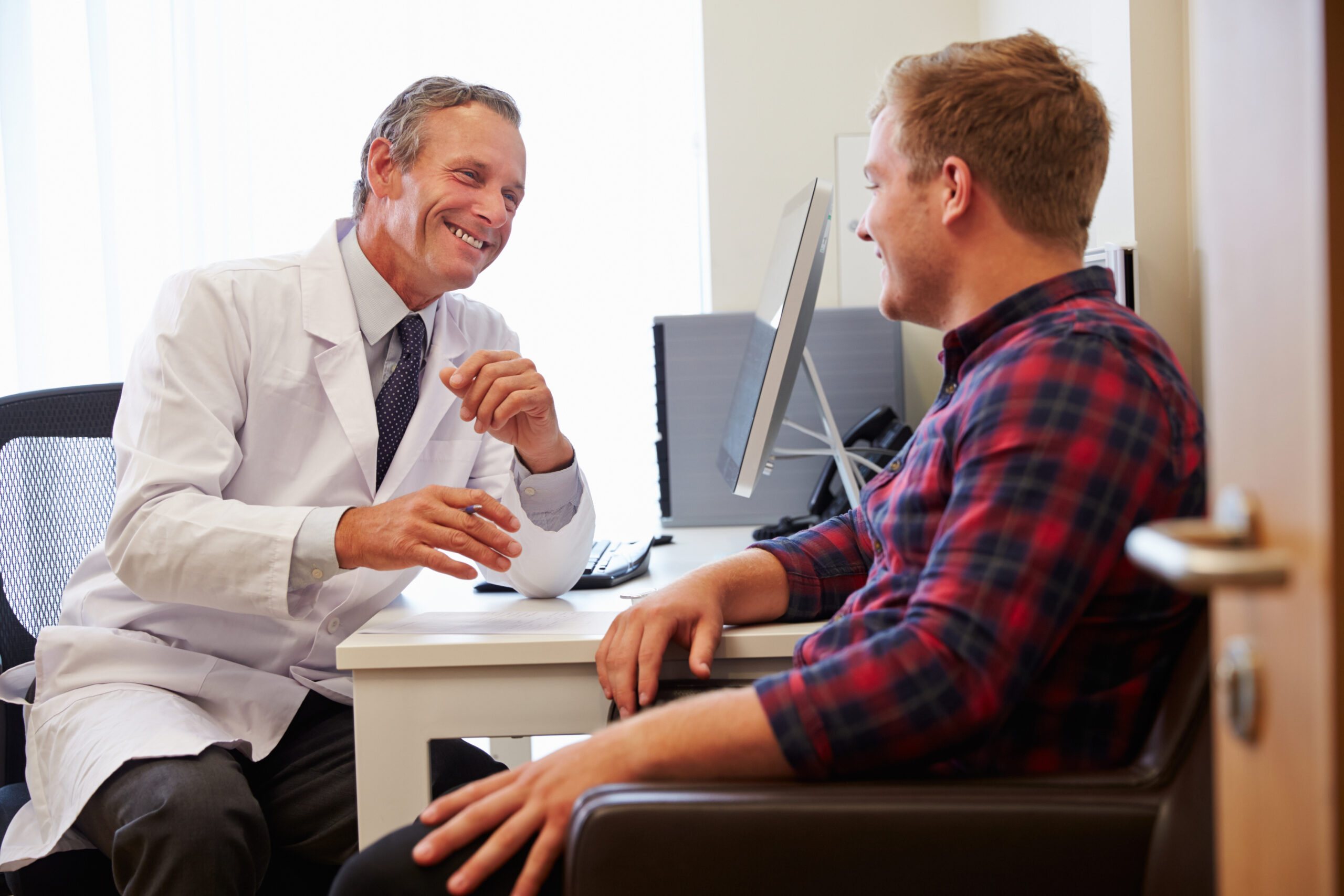 Man consulting with doctor about minoxidil side effects