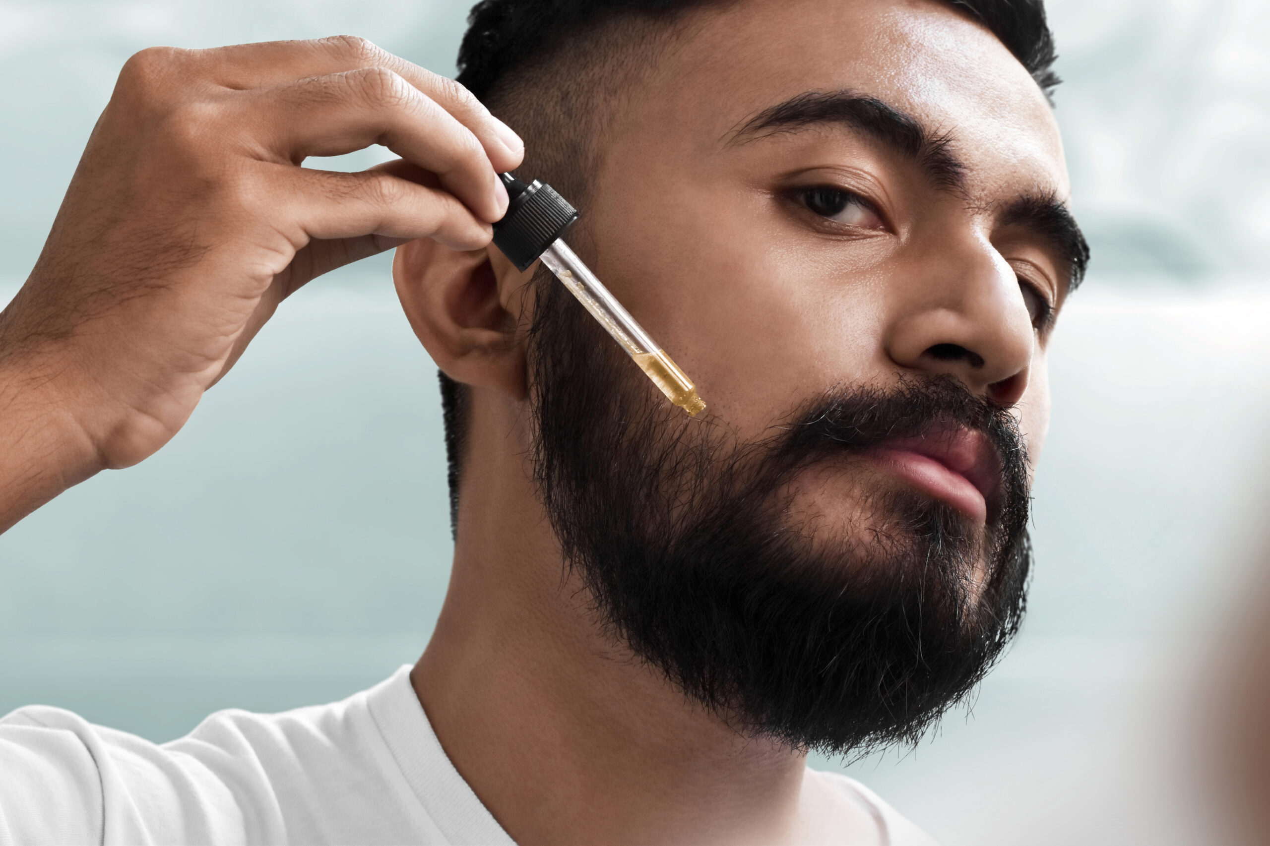 Man applying minoxidil to his beard