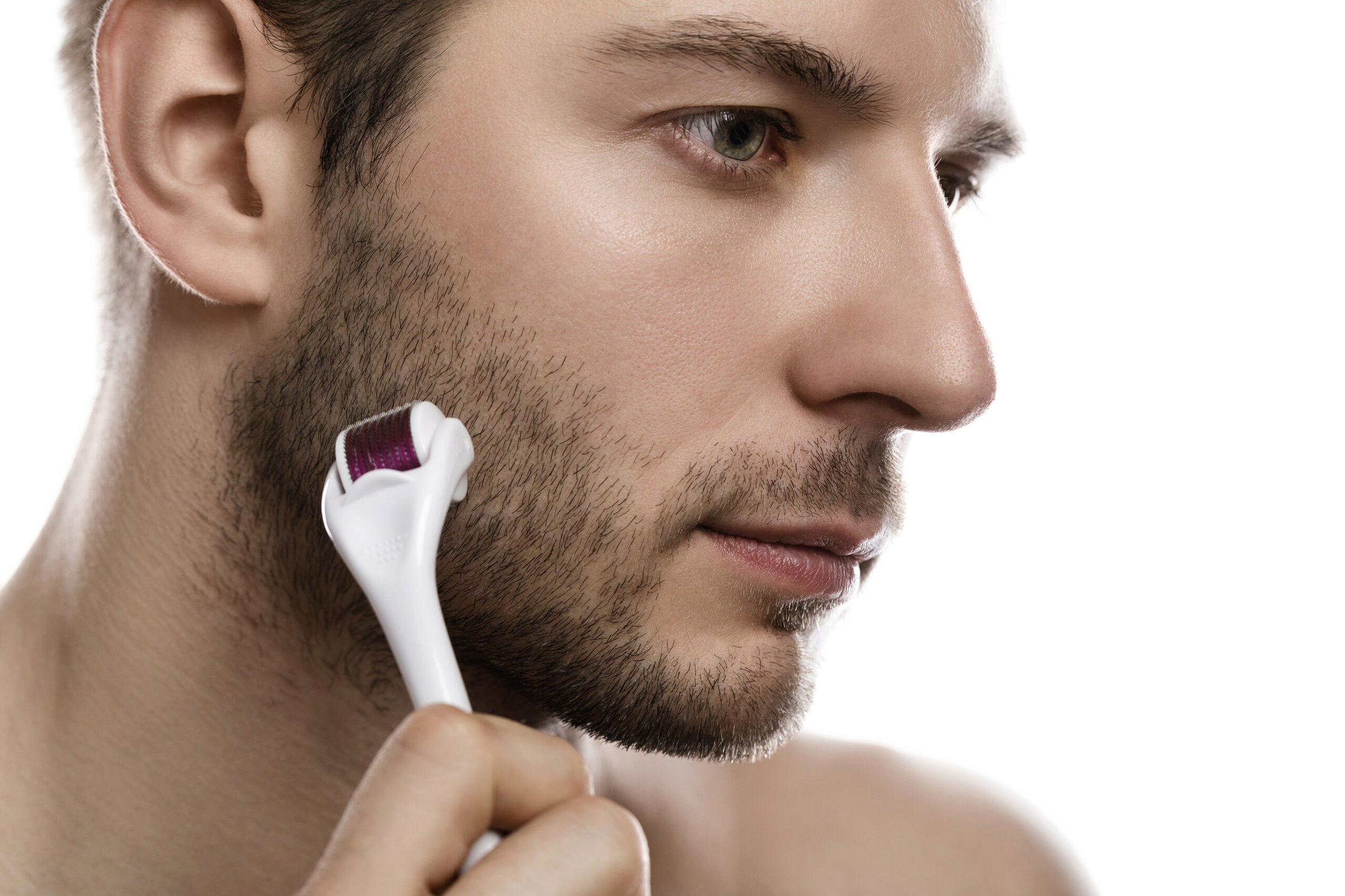man using derma roller for beard growth